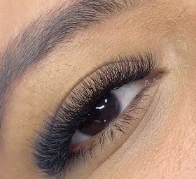 Close de um olho com extensão de cílios aplicada fio a fio